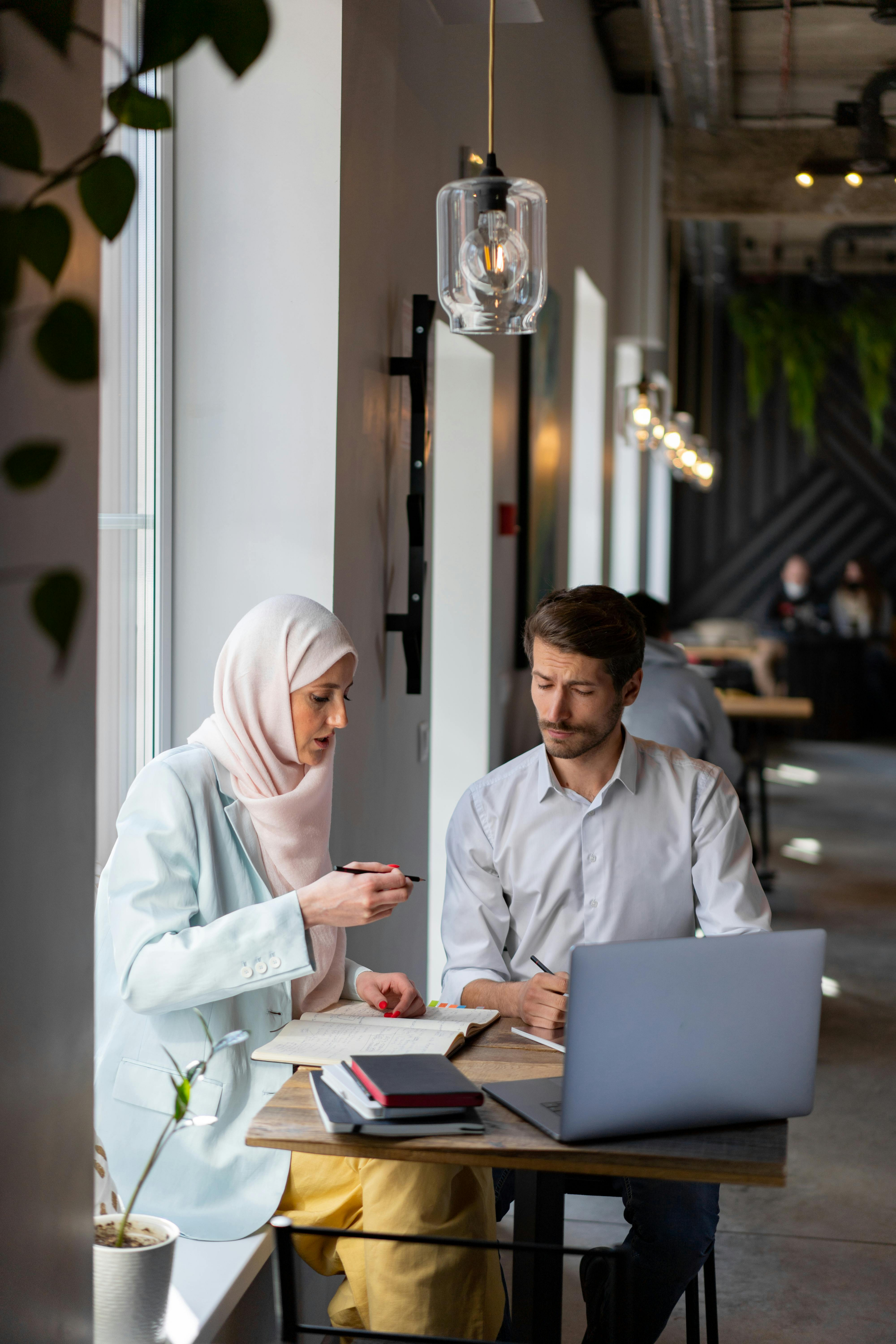 Lady explaining some concepts to a man with a laptop